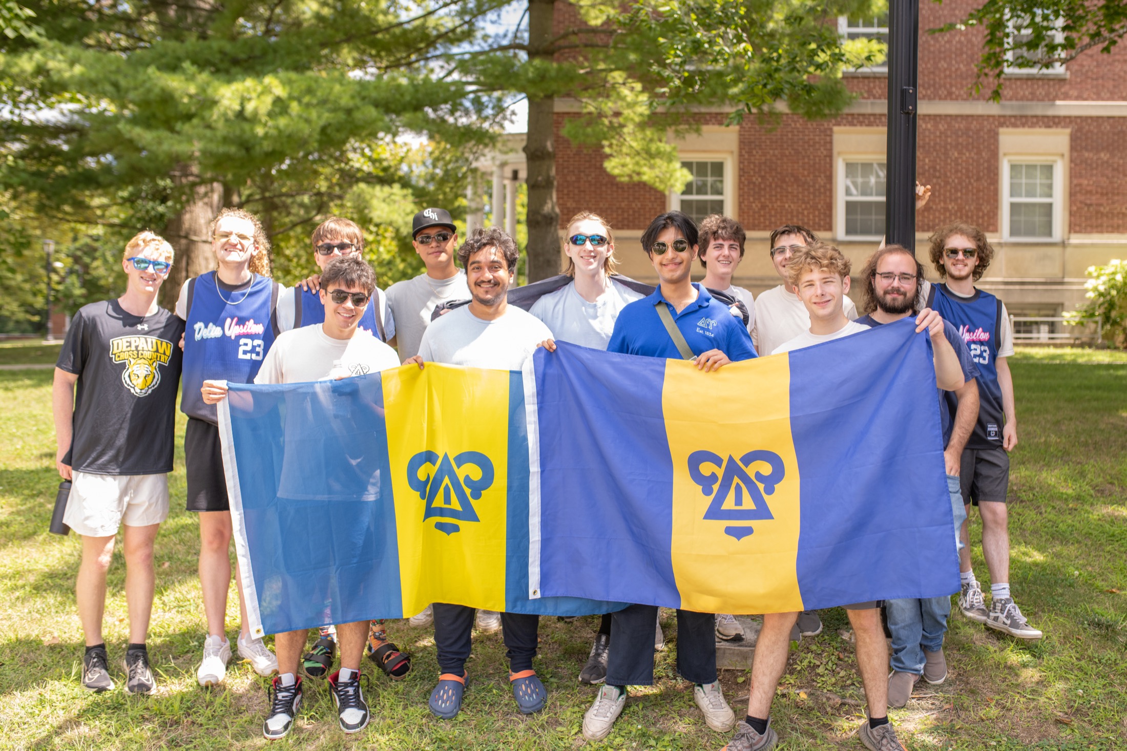 DePauw Delta Upsilon members holding chapter flags.
